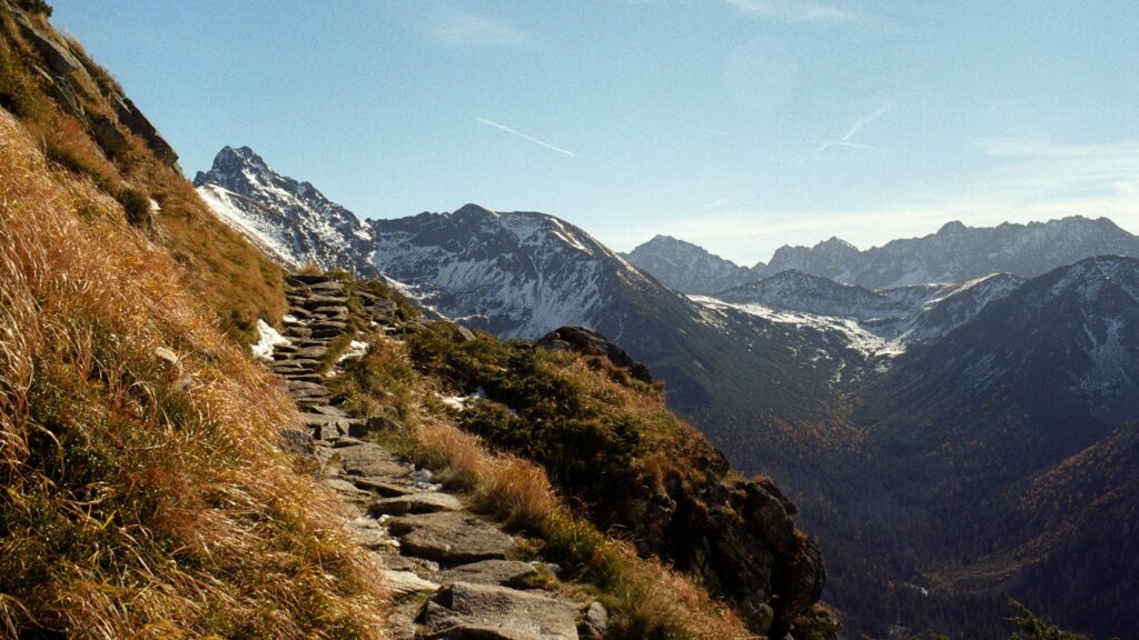 Schmaler alpiner Bergpfad mit weiter Bergkulisse